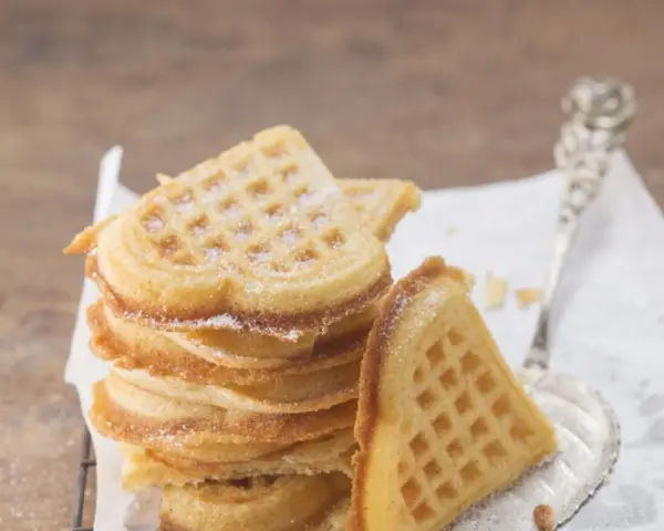 Herzförmige Waffeln, bestäubt mit Puderzucker. Ein perfektes Rezept für süße Momente.