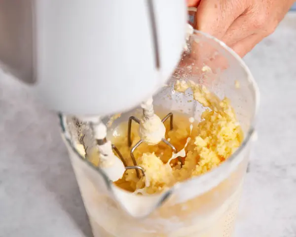 Hand mixt Sahne zu Butter. Der Prozess, um Butter selber machen, ist faszinierend.