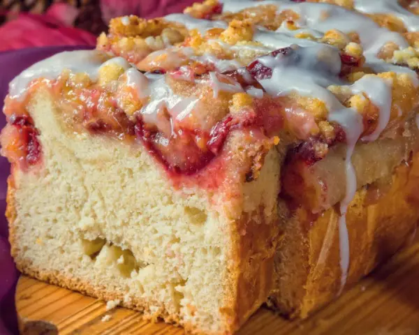 Saftiger Pflaumenkuchen in Kastenform, mit Streuseln und Zuckerguss überzogen, bereit zum Genießen.