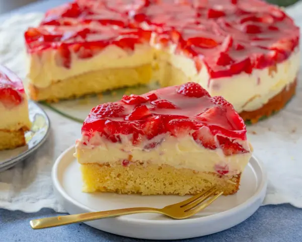 Ein saftiger Erdbeerkuchen mit cremiger Füllung und rotem Tortenguss. Perfekt für leckere obstkuchen rezepte.