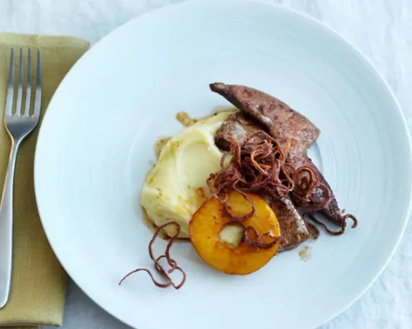 Kalbsleber rezept: Gebratene Kalbsleber mit Kartoffelpüree, Apfelring und knusprigen Zwiebeln auf einem weißen Teller.