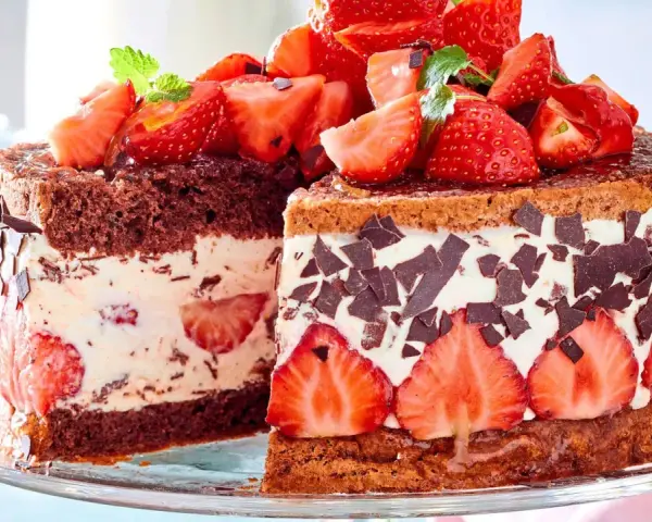 Ein saftiger Erdbeerkuchen mit Quarkfüllung, dekoriert mit frischen Erdbeeren und Schokoladenstückchen.