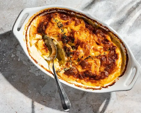 Ein goldbraunes Kartoffelgratin mit Kräutern, bereit zum Servieren. Dieses Kartoffelgratin Rezept ist ein Genuss!
