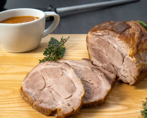 Saftiger Schweinenacken, aufgeschnitten und mit Soße serviert. Ein köstliches Schweinenacken Rezept für jeden Anlass.