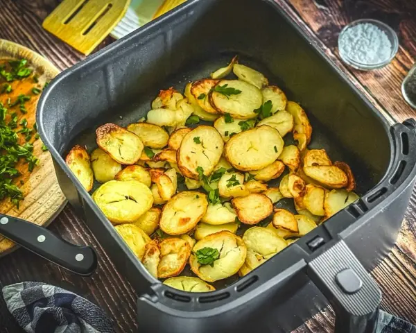 Goldbraune bratkartoffeln im Airfryer, garniert mit frischer Petersilie. Perfekt als Beilage oder Snack.