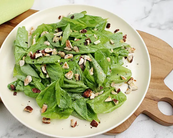 Frischer Spinatsalat mit gehackten Nüssen, ein einfaches und leckeres spinatsalat rezept.