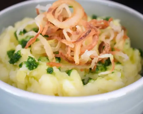 Cremiger Kartoffelbrei, verfeinert mit frischen Kräutern und knusprigen Röstzwiebeln. Ein einfaches Kartoffelbrei Rezept, das immer gelingt.