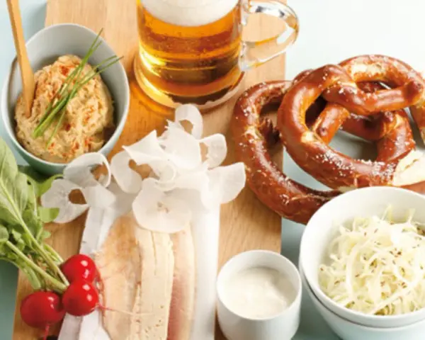 Herzhaftes bayerisches Vesper: Brezn, Bier, Obatzda, Radieschen und der weltbester Krautsalat.
