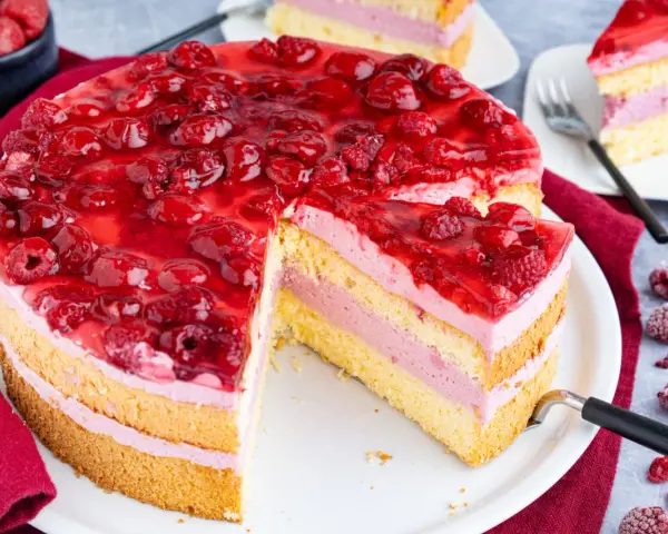 Himbeertorte mit gefrorenen Himbeeren: saftiger Biskuit, cremige Füllung und fruchtiges Topping. Ein köstliches Rezept!