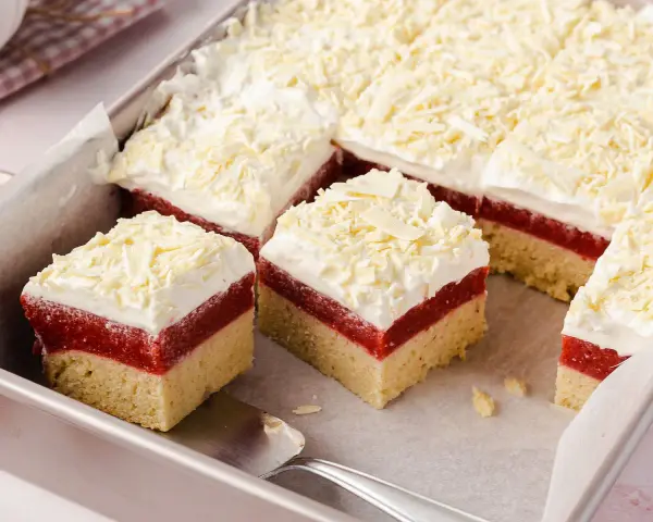 Schichtkuchen mit roter Fruchtschicht, weißer Creme und Schokostreuseln – perfekt als Kuchen zum Muttertag.