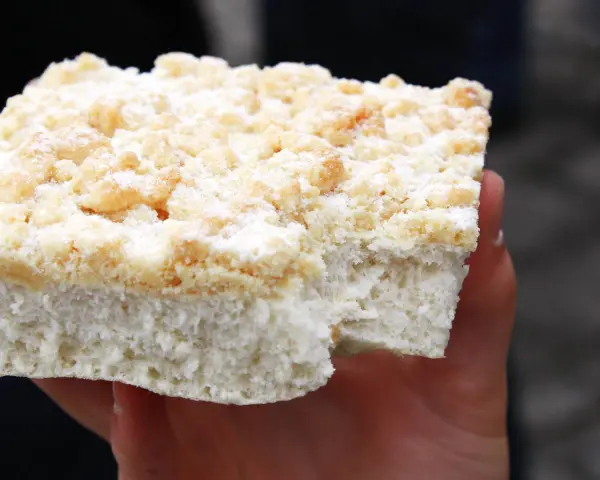 Ein Stück Kuchen mit Streuseln, die ohne Butter zubereitet wurden, liegt auf einer Hand.