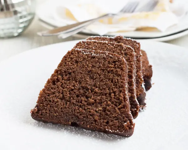 Saftige Scheiben eines Schokoladenkuchens, bestäubt mit Puderzucker. Ein köstlicher Nutella Kuchen, bereit zum Genießen.
