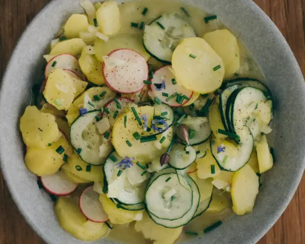 Frischer Kartoffelsalat mit Gurken, Radieschen und Schnittlauch. Ein tolles Rezept für den Sommer!
