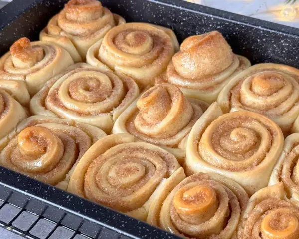 Frisch gebackene Zimtschnecken im Blech, bereit für das Zimtschnecken Rezept. Goldbraun und duftend.