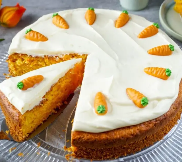 Ein saftiger Karottenkuchen mit cremigem Frosting, dekoriert mit kleinen Marzipan-Karotten. Perfekt für jedes Karottenkuchen Rezept!