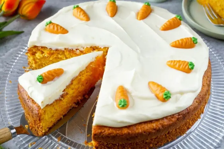 Ein saftiger Karottenkuchen mit cremigem Frosting, dekoriert mit kleinen Marzipan-Karotten. Perfekt für jedes Karottenkuchen Rezept!