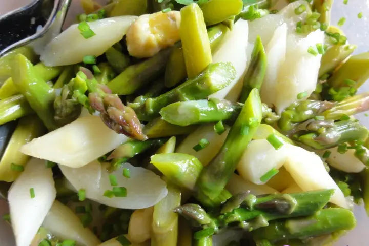 Frischer Spargelsalat mit grünen und weißen Spargelstangen, verfeinert mit Schnittlauch. Ein leichtes und gesundes Spargelsalat Rezept.