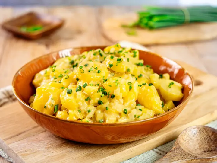 Ein köstlicher Kartoffelsalat, perfekt für jedes Kartoffelsalat Rezept. Mit frischen Kräutern garniert, bereit zum Servieren.