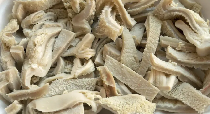 Gekochte und geschnittene Kutteln für ein herzhaftes Kutteln Rezept. Die Textur ist faserig und leicht wellig.