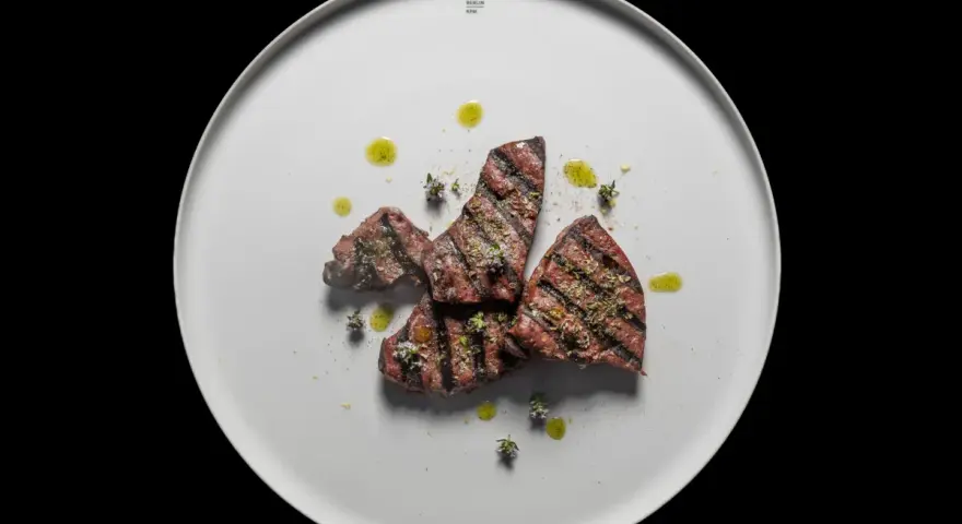 Gebratene Leberstücke mit Kräutern und Olivenöl auf einem weißen Teller. Ein einfaches, aber köstliches Leber Rezept.
