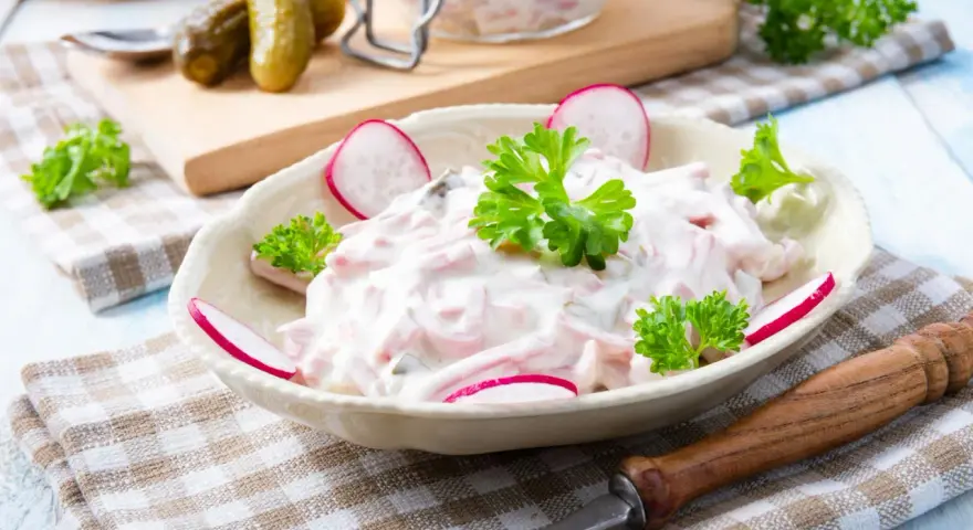Ein cremiger Fleischsalat, garniert mit Radieschen und Petersilie. Ein einfaches und leckeres rezept fleischsalat für jede Gelegenheit.