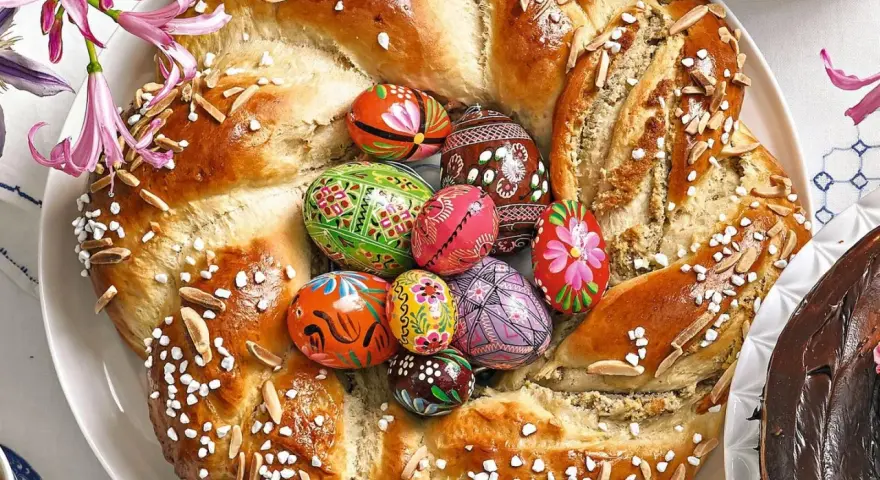 Bunter Osterkranz mit verzierten Eiern und Mandelsplittern, perfekt zum Backen zu Ostern.