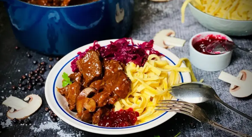 Herzhaftes Rehgulasch mit Spätzle, Rotkohl und Preiselbeeren. Ein köstliches Rehgulasch Rezept für Genießer.