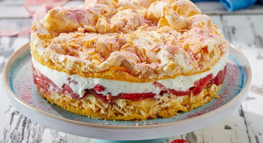 Ein köstlicher Rhabarberkuchen mit Baiser, wie ihn Landfrauen backen. Mit Mandelsplittern und roter Puderzucker-Deko.