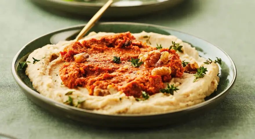 Cremiges Bohnenmus mit würziger Tomaten-Walnuss-Mischung und frischen Kräutern. Ein köstliches Rezept für Bohnenmus!