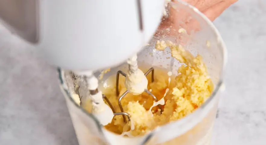 Hand mixt Sahne zu Butter. Der Prozess, um Butter selber machen, ist faszinierend.