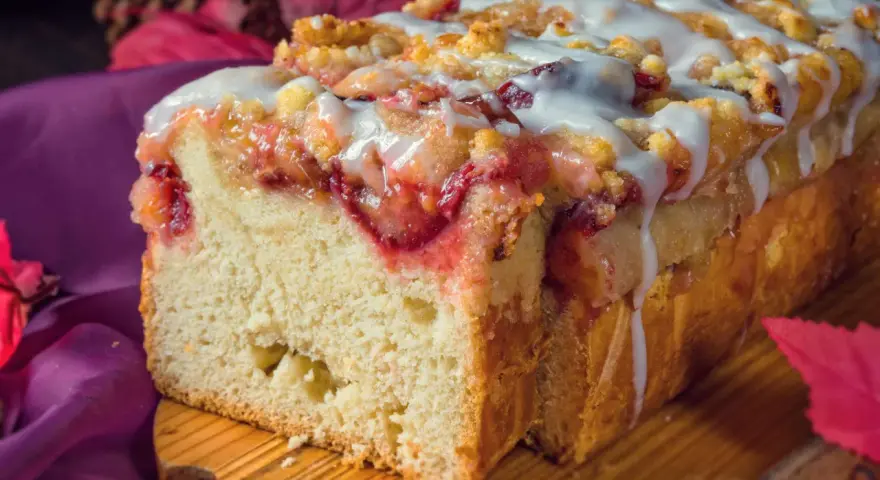 Saftiger Pflaumenkuchen in Kastenform, mit Streuseln und Zuckerguss überzogen, bereit zum Genießen.