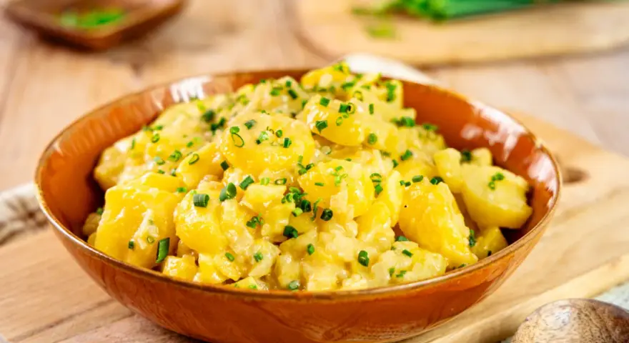 Ein köstlicher Kartoffelsalat, perfekt für jedes Kartoffelsalat Rezept. Mit frischen Kräutern garniert, bereit zum Servieren.