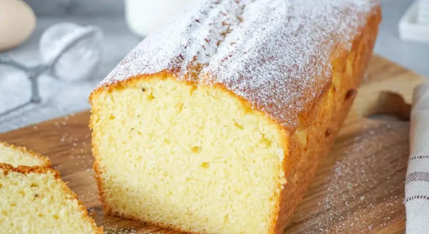 Ein saftiger Kastenkuchen, bestäubt mit Puderzucker, perfekt für einfache Kastenkuchen Rezepte.