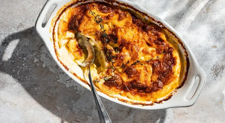 Ein goldbraunes Kartoffelgratin mit Kräutern, bereit zum Servieren. Dieses Kartoffelgratin Rezept ist ein Genuss!