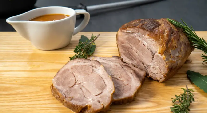 Saftiger Schweinenacken, aufgeschnitten und mit Soße serviert. Ein köstliches Schweinenacken Rezept für jeden Anlass.
