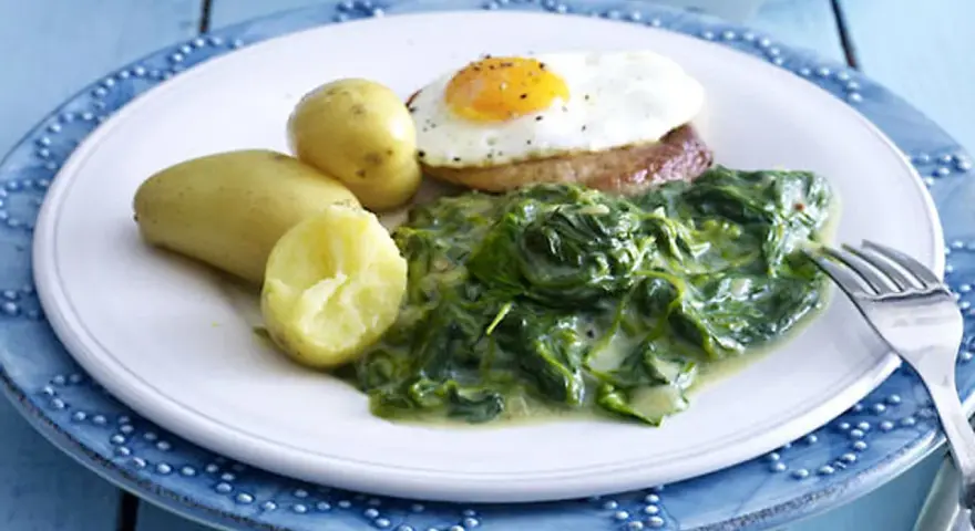 Ein Teller mit Rahmspinat, Kartoffeln und Spiegelei. Ein einfaches und leckeres Rahmspinat Rezept.