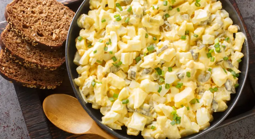 Cremiger Eiersalat mit Gurkenstückchen und Schnittlauch, perfekt für ein einfaches eiersalat rezept. Dazu passen rustikale Brotscheiben.