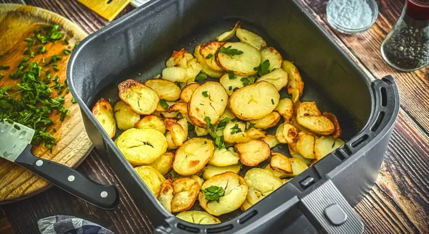 Goldbraune bratkartoffeln im Airfryer, garniert mit frischer Petersilie. Perfekt als Beilage oder Snack.