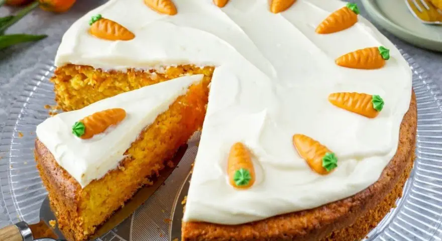 Ein saftiger Karottenkuchen mit cremigem Frosting, dekoriert mit kleinen Marzipan-Karotten. Perfekt für jedes Karottenkuchen Rezept!