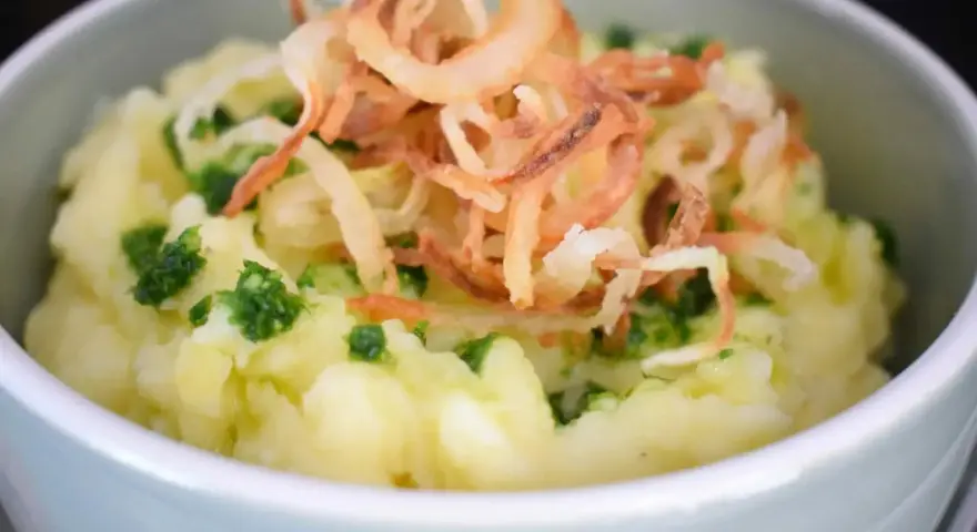 Cremiger Kartoffelbrei, verfeinert mit frischen Kräutern und knusprigen Röstzwiebeln. Ein einfaches Kartoffelbrei Rezept, das immer gelingt.