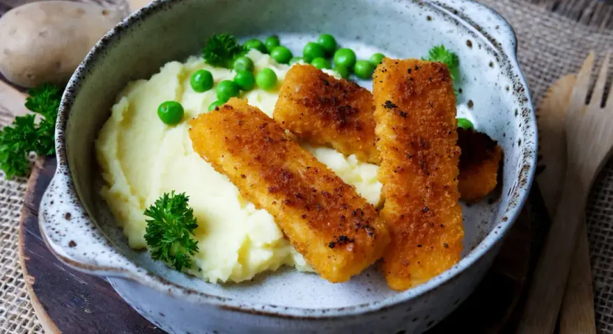 Knusprige Fischstäbchen auf cremigem Kartoffelbrei mit Erbsen und Petersilie – schnelle Gerichte mit Kartoffelbrei, die immer schmecken.