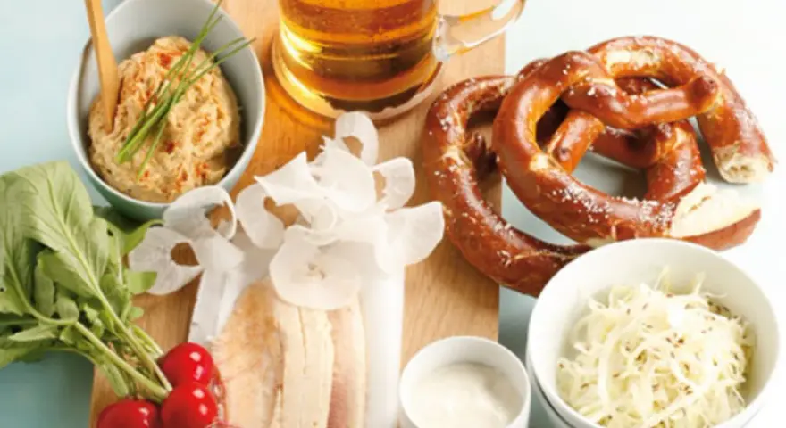 Herzhaftes bayerisches Vesper: Brezn, Bier, Obatzda, Radieschen und der weltbester Krautsalat.