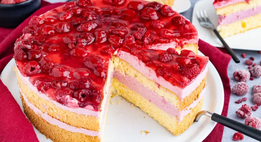 Himbeertorte mit gefrorenen Himbeeren: saftiger Biskuit, cremige Füllung und fruchtiges Topping. Ein köstliches Rezept!
