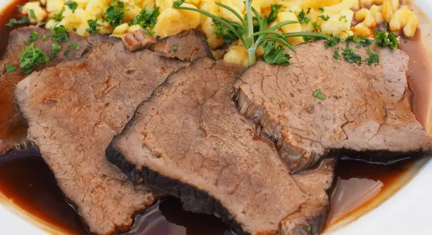 Saftige Scheiben Sauerbraten mit Spätzle und einer Kräutergarnitur. Ein klassisches Sauerbraten Rezept, das Appetit macht.