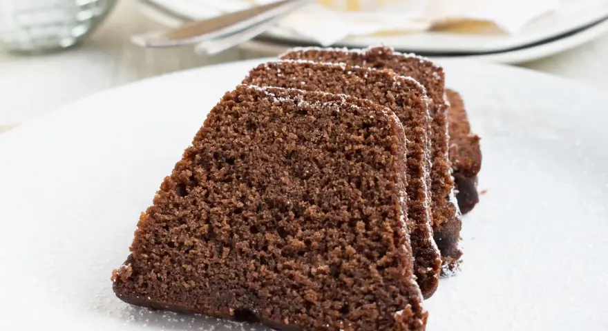 Saftige Scheiben eines Schokoladenkuchens, bestäubt mit Puderzucker. Ein köstlicher Nutella Kuchen, bereit zum Genießen.
