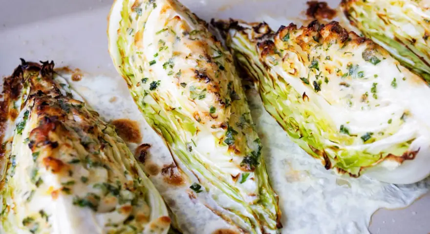 Gegrillte Spitzkohl-Spalten mit Kräutern und Käse, ein köstliches Gericht, das Lust auf mehr Spitzkohl Rezepte macht.