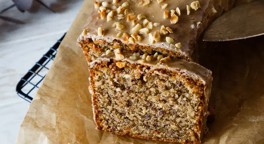 Saftiger Nusskuchen mit Zuckerguss und gehackten Nüssen, perfekt für ein gemütliches Kaffeetrinken. Ein tolles Nusskuchen Rezept!