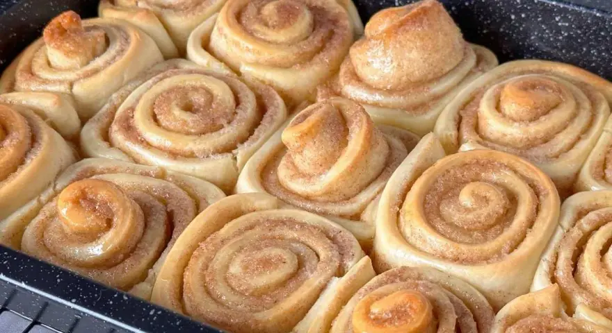 Frisch gebackene Zimtschnecken im Blech, bereit für das Zimtschnecken Rezept. Goldbraun und duftend.