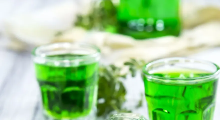 Grüne Gläser mit Waldmeistersirup, perfekt zum Waldmeistersirup selber machen. Frische Kräuter und ein Hauch von Frühling.