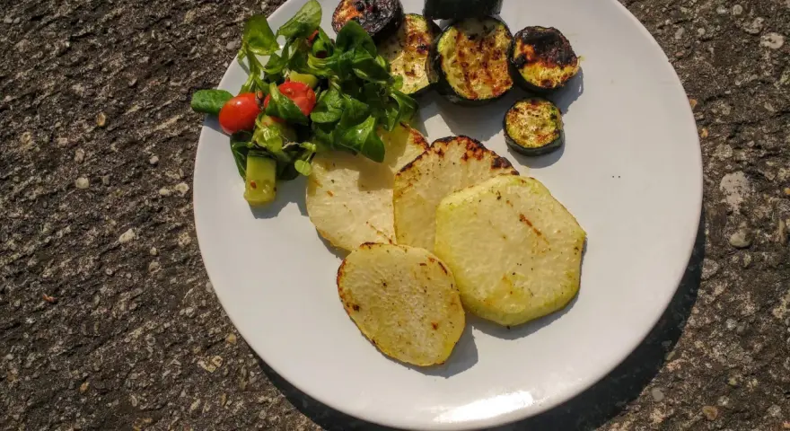 Gegrillte Kohlrabi-Scheiben mit Zucchini und einem kleinen Salat. Ein leckeres Gericht, das Lust auf Kohlrabi grillen macht.